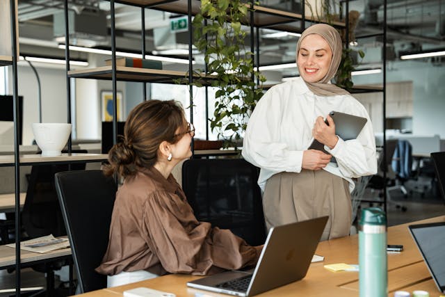 Two colleagues talking to each other in an office